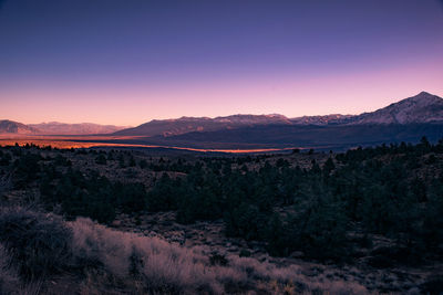 Scenic view of landscape against dramatic sky at sunset