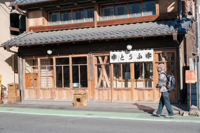 Man standing on road by building