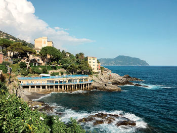 Scenic view of sea by buildings against sky