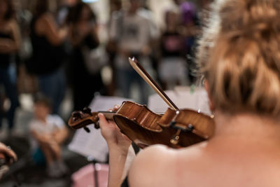 Rear view of a young woman playing guitar