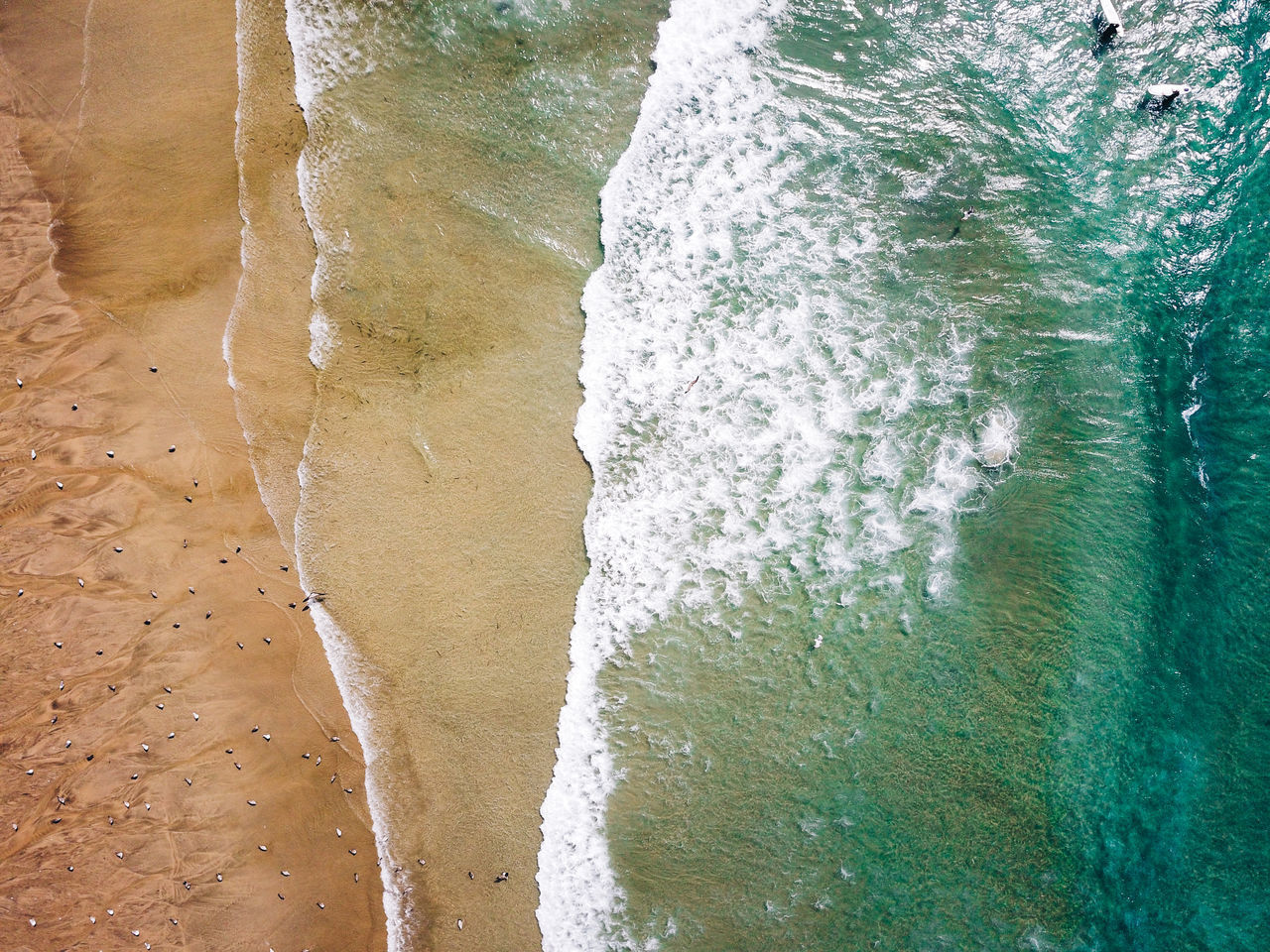 HIGH ANGLE VIEW OF WAVE RUSHING TOWARDS SHORE