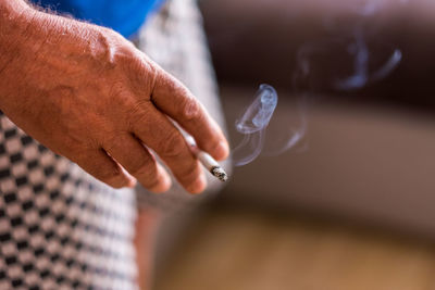 Cropped hand of man holding cigarette