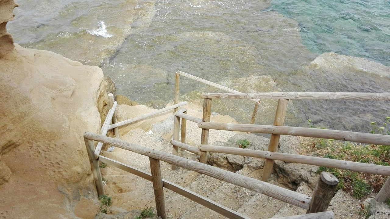 high angle view, staircase, railing, architecture, no people, day, nature, steps and staircases, water, built structure, solid, wood - material, sea, rock, outdoors, metal, security, rock - object, protection, ladder