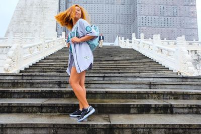 Young woman standing by railing