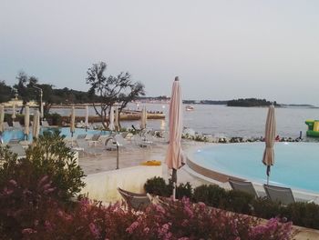 View of swimming pool by sea against clear sky