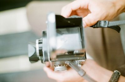 Cropped hands holding vintage camera