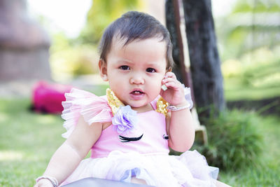 Portrait of cute girl sitting outdoors