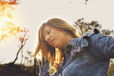 Portrait of smiling young woman against sky during sunset
