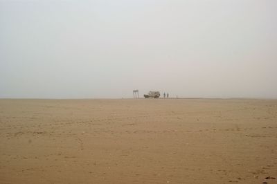 People by off-road vehicle at namib desert in foggy weather