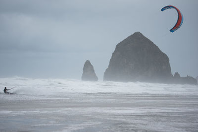 Scenic view of person kiteboarding