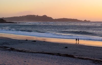 Scenic view of beach against clear sky during sunset