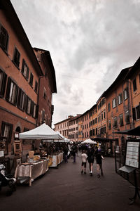 People walking on street amidst buildings in city