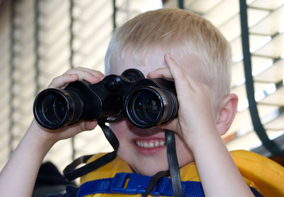 Close-up portrait of boy holding camera