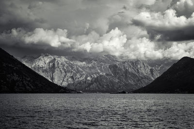 Scenic view of lake by mountains against sky