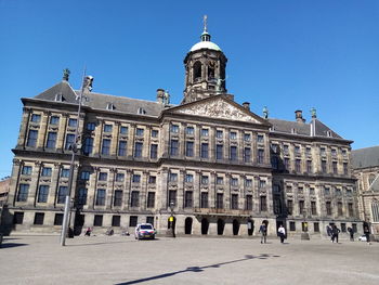 Buildings in city against clear blue sky