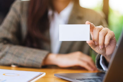 Midsection of woman using laptop on table