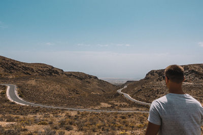 Man standing on mountain against sky