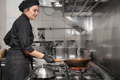 Side view of man working in kitchen