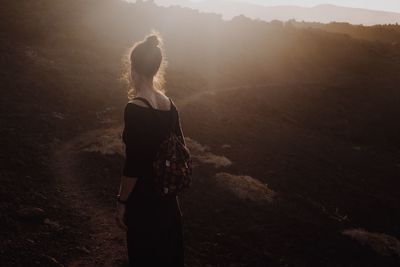 Rear view of woman standing on land