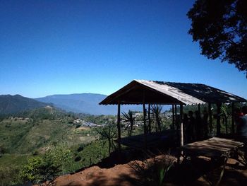 Built structure on landscape against clear blue sky