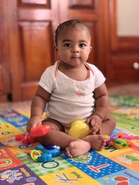 Cute boy playing with toy blocks at home