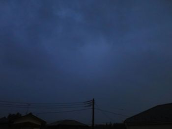 Low angle view of silhouette electricity pylon against sky