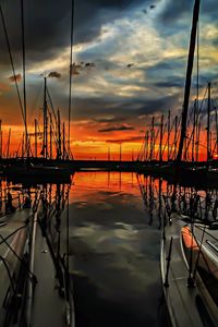 View of sailboat in sea against cloudy sky at sunset