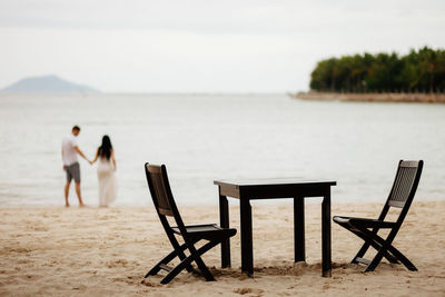 Rear view of two people on beach