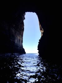 Rock formation in sea against sky