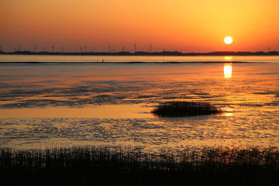 Scenic view of sea against orange sky