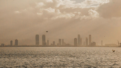 View of city by sea against sky