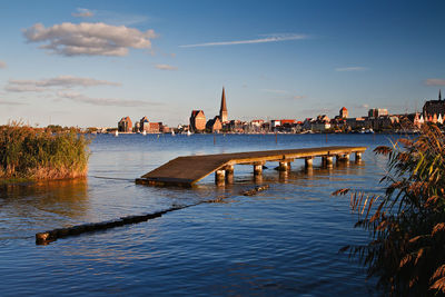 Pier over warnow river against sky