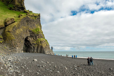 People on beach against sky