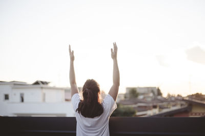 Rear view of woman standing in front of building