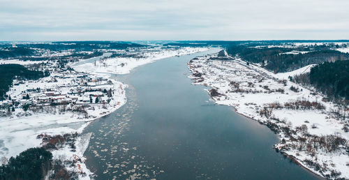 Aerial view of city by sea against sky