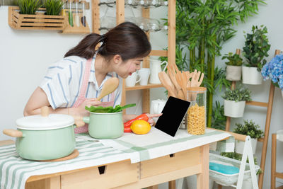 Rear view of woman holding food on table