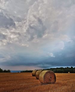 Hay bales on field against sky