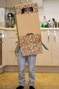 Portrait of a cute, blue-eyed boy playing inside a cardboard box