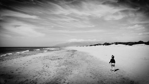 Silhouette man standing on beach against sky