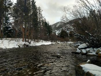 View of river flowing through snow covered land