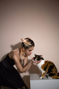 Woman with cat against colored background