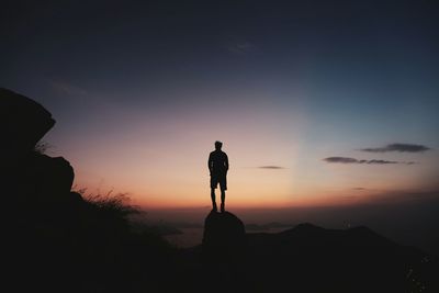 Silhouette of man looking at sunset