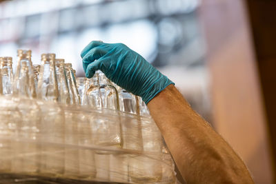 Cropped hand of man reaching to bottle