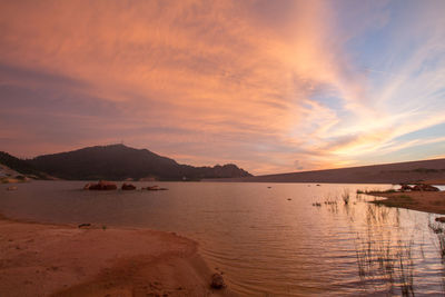 Scenic view of beach against sky during sunset