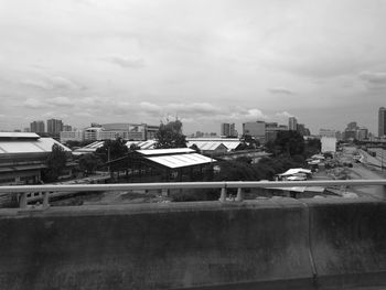 View of cityscape against cloudy sky