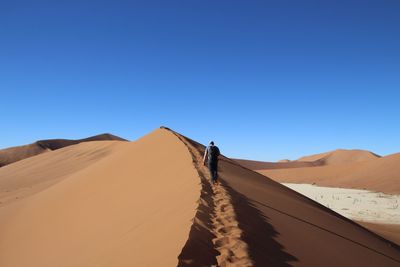 Scenic view of desert against clear blue sky