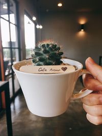 Close-up of hand holding coffee cup