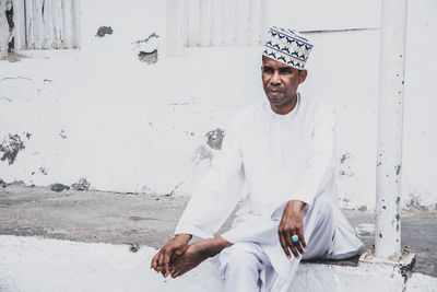 Man sitting in a traditional clothing standing outdoors