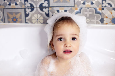 Cute girl sitting in bath tub