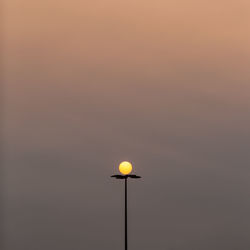 Low angle view of street light against sky at sunset